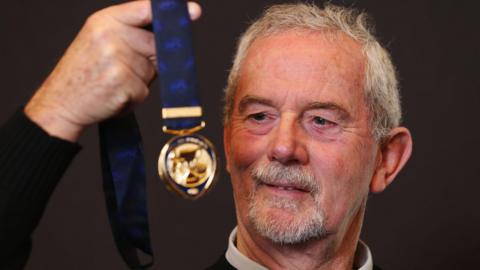 Robert Walls holding a medal