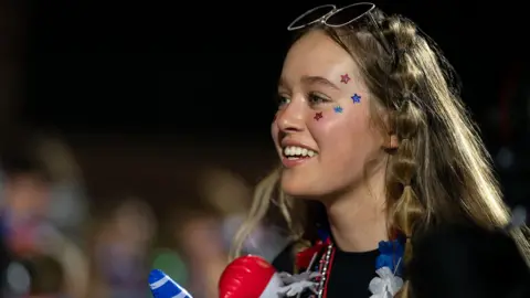 A girl with small red and blue stars on her face