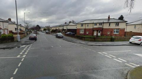 The junction of residential streets Arnhem Road and Fishwick Parade in Preston taken on a cloudy day.