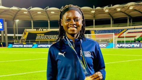 Nigerian football referee Gbemisola Yusuf poses with her medal in a stadium