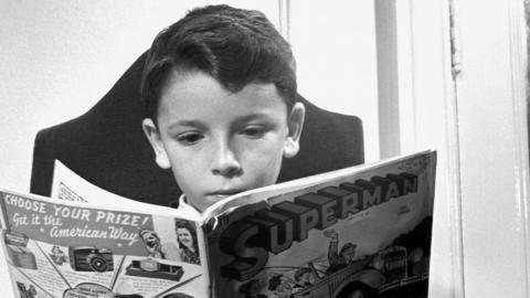 A black and white photo from 1942 of a child reading a Superman comic book
