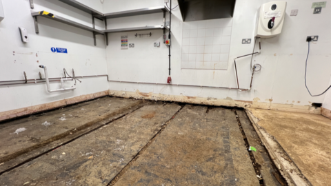 Flooded flooring with empty shelves and water damage