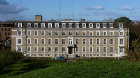 A grand five-storey building with large windows.