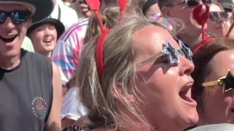 Crowd singing in the sunshine