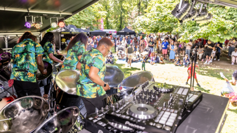 People on stage playing steel pans