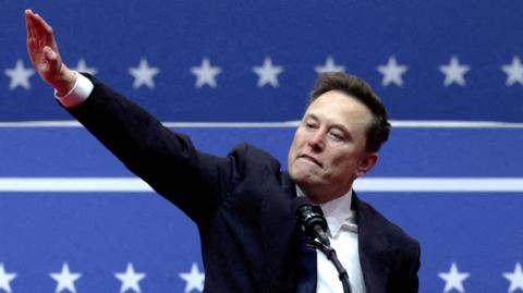 Musk gestures with one arm outstretched inside the Capital One arena in Washington on the inauguration day of Donald Trump