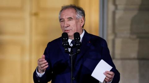 France's new prime minister François Bayrou (on the left) arrives at the prime minister's residence in Paris where he is greeted by the man who was ousted from the job last week