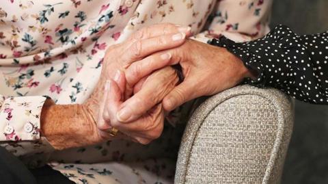 Generic image of the clasped hands of two women