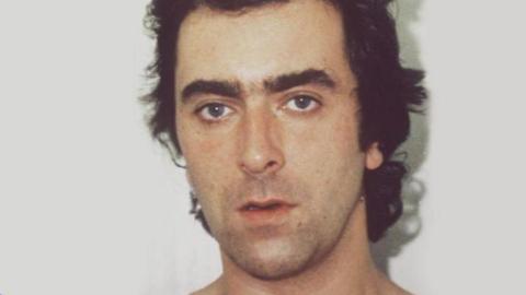 John Cannan staring at the camera in a police mugshot