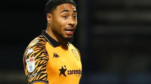 Akin Famewo in action for Hull City in their amber home shirt