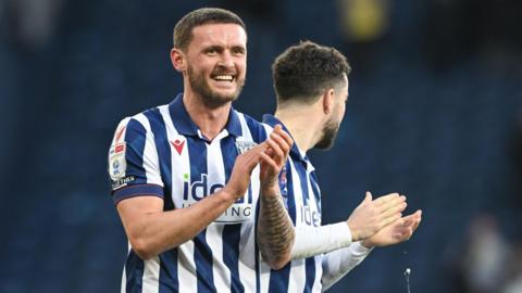 John Swift smiles and claps the crowd after a game for West Bromwich Albion