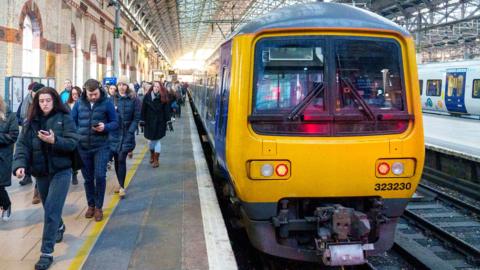 Commuters disembark a train as they arrive at Manchester Piccadilly railway station in Manchester, UK, on Thursday, Dec 8, 2022