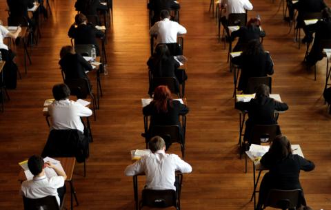 An exam hall with students sitting at desks. 