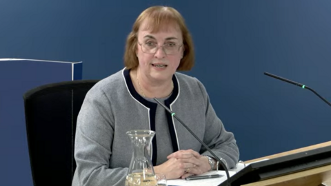 Prof Jean White sat at a desk as she gives evidence to the Covid inquiry