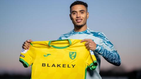 Lewis Dobbin holding a  Norwich City shirt