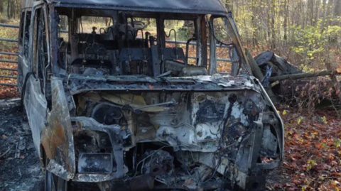 The stolen minibus, burnt out and destroyed in a field.