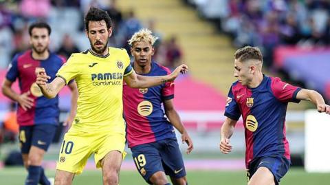 Villarreal's Dani Parejo with the ball under pressure from Barcelona's Fermin Lopez and Lamine Yamal.