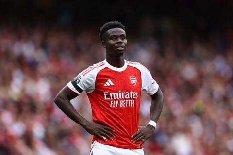 Bukayo Saka wearing Arsenal home kit whilst playing a match