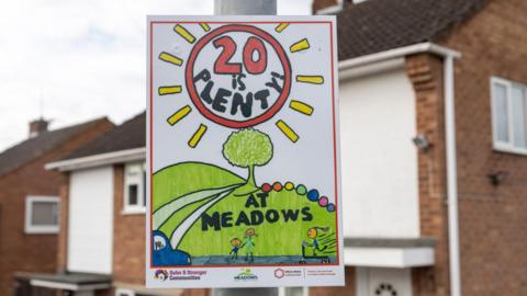 Road sign saying "20 is plenty at Meadows"