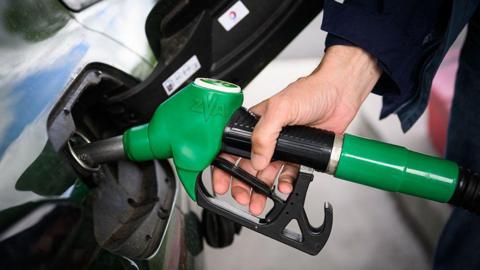 A driver fills up their car with petrol.
