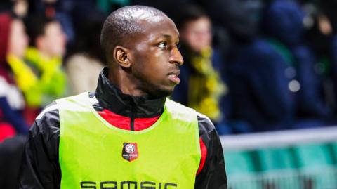 Glen Kamara wearing a green bib and looking to the side