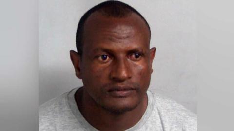 Hadush Kebatu in a grey sweater looking at camera.