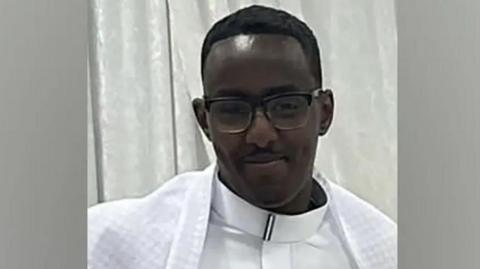 File image showing Mohamed Noor, a young man wearing glasses and white clothing