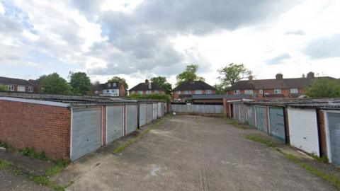 Some of the garages on land rear of Shepherds Lane in Bracknell. It is a cloudy day.