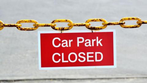 A red sign attached for a yellow chain. 