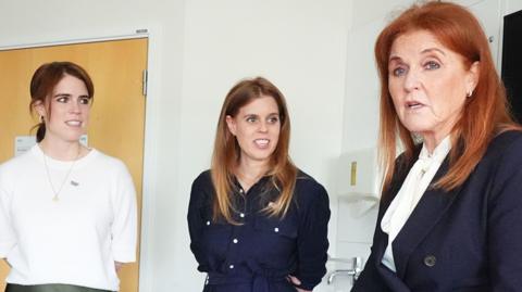 Then-Sarah, Duchess of York and her daughters Princess Beatrice and Princess Eugenie speak to patient Lennon Pearson during a visit to the Teenage Cancer Trust unit at University College Hospital, London