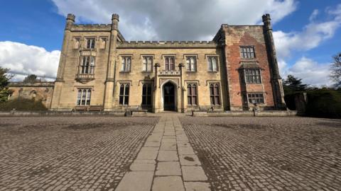 Georgian style castle infront of pebbled grounds 
