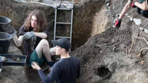 Two students in the trenches digging for skeletons and artefacts