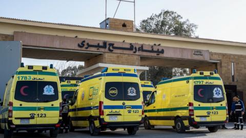 A line of yellow ambulances queue up at Gaza's Rafah crossing with Egypt.