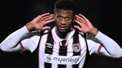 Grimsby's Justin Obikwu cups his hands to his ears after scoring against Accrington.