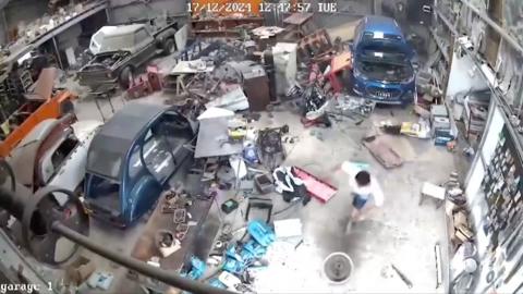 Person running inside a garage as earthquake strikes and items fall to floor