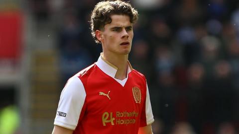Harry Gray in action for Rotherham United wearing their red home jersey