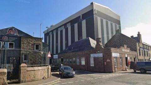 buildings at a harbour with cars parked in front