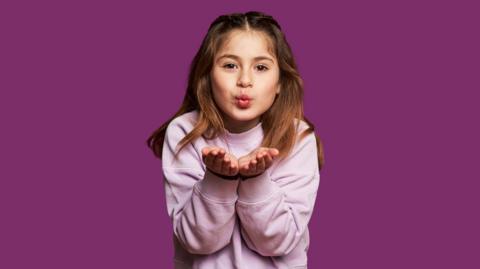 A girl blowing a kiss to the camera