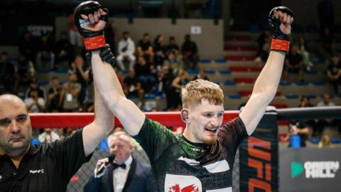 Ioan Harris with arms held aloft celebrates wining the 2022 IMMAF European Championship