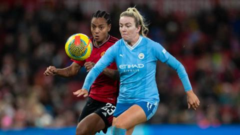 Lauren Hemp battles for the ball with Manchester United forward Geyse