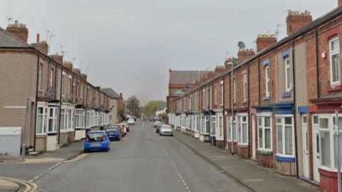 Row of terraced houses and cars parked on the road.