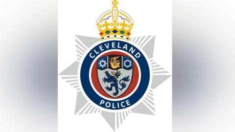 Graphic of the new Cleveland Police crest, which includes a gold crown at the top decorated with red, green and purple jewels. Below the crown is a shield featuring several images. Around the shield is a blue circle with "Cleveland Police" in white writing.