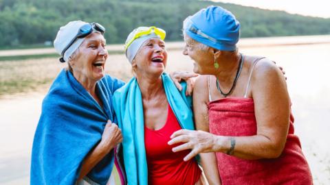 Three women laughing in swimming clothing