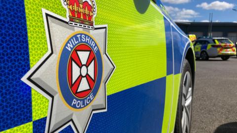 A close up of the side of a Wiltshire Police car door