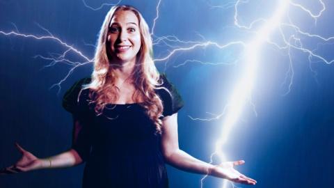 Sophia Herod standing in front of a green screen showing lightning
