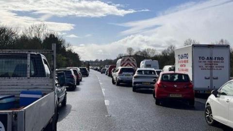Several vehicles in a queue on the M5 carriageway, southbound, in Devon