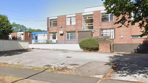 A derelict building and an abandoned car park