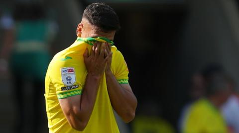 Marcelino Nunex covers his face with his Norwich City shirt
