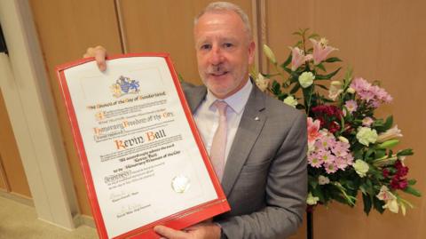 Kevin Ball holding up his certificate saying he had been given the Freedom of Sunderland