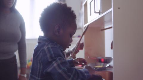 Toddler playing with wooden spoon.